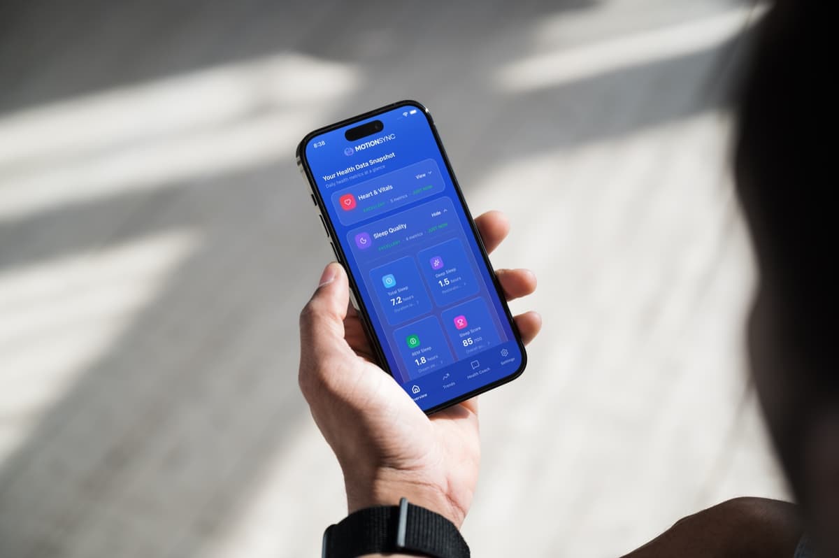 Person reviewing their health dashboard on a tablet while sitting at a modern desk with a smartwatch visible on their wrist